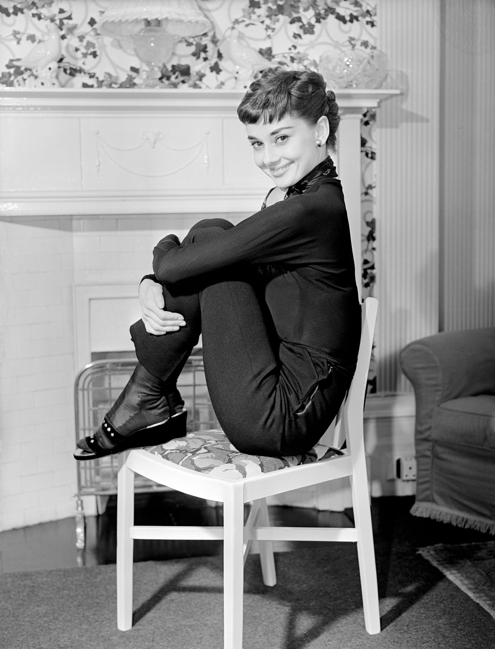 Image may contain Audrey Hepburn Person Sitting Clothing Footwear Shoe Face Head Photography Portrait and Chair