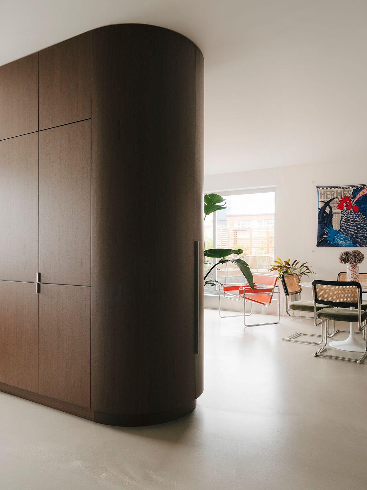 En face le module en weng spare le salon de la cuisine dissimulant des portes de rangement ainsi qu'un bar.