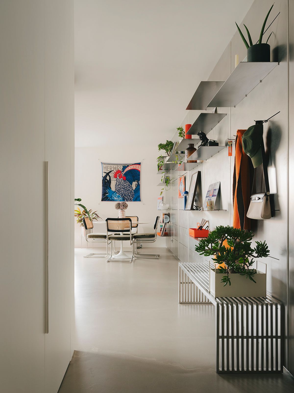 Le mur en inox mène de l'entre au fond de la pièce à vivre.