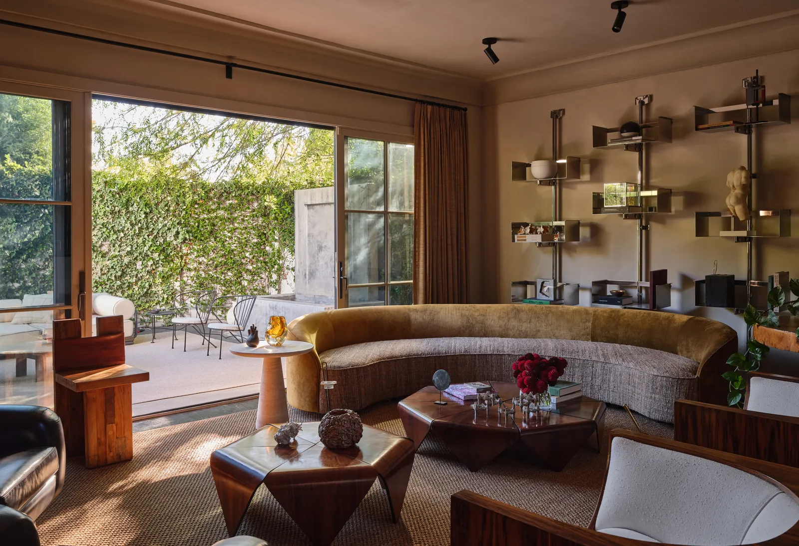 Dans le salon le canap de Neobox côtoie les tables basses Petalas et les fauteuils Cube de Jorge Zalszupin une table de José Zanine Caldas, des fauteuils courbes noirs de Joaquim Tenreiro, le tabouret Sesc de Lina Bo Bardi et des étagères de Vittorio Introini. Aux murs, A calopsita (2024) d’Adriana Varejão apporte une touche de couleur plus intense à l’espace.