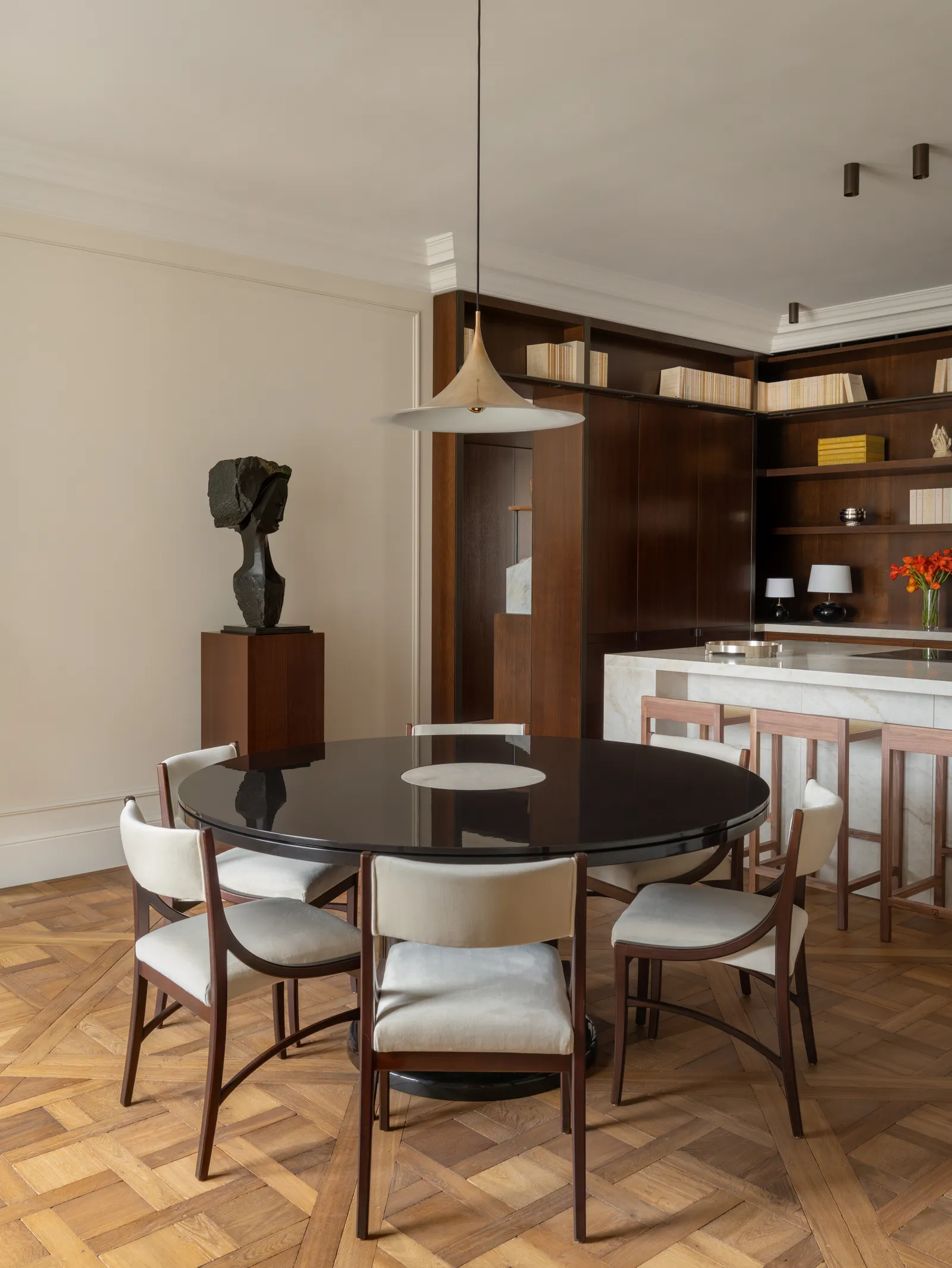 La bibliothèque-cuisine s'ouvre sur une salle à manger au look très parisien. Sculpture Hlène Lalbaltry. Suspension et table, Hugues De Blignières. Chaises et lampe, Darle Malotaux.